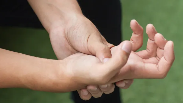 Close up of man holding hand in pain