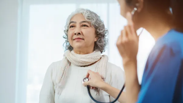 Doctor with stethoscope examining elderly patient with examination