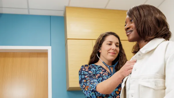 Provider listening to young woman's heart