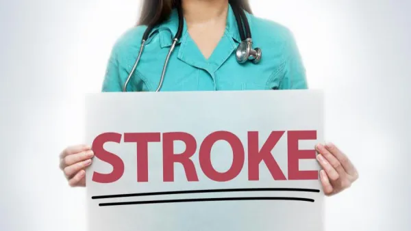 Woman holding sign that says STROKE