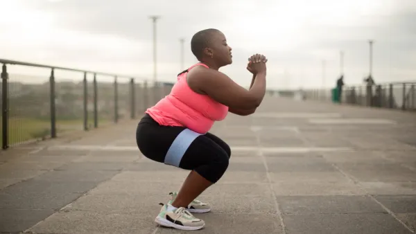 Woman doing squats on a bridge