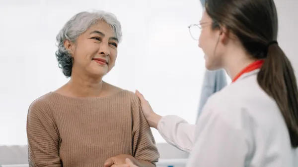 Doctor talking to older woman, putting her hand on her shoulder