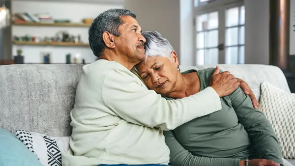 Man and woman sitting and hugging on couch