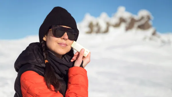 Woman applying sunscreen to her face