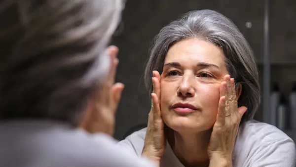 Woman looking at her face in the mirror