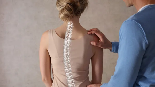 Provider examining woman's back with curved spine