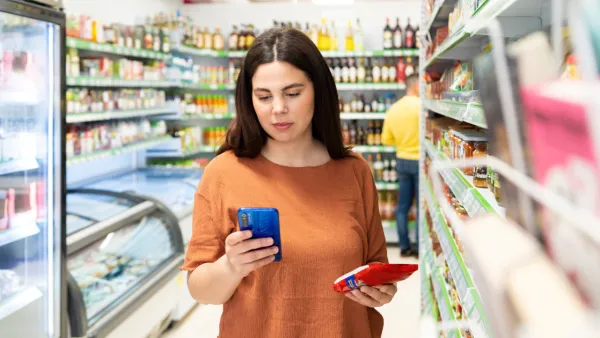 Woman in grocery store looking at her phone