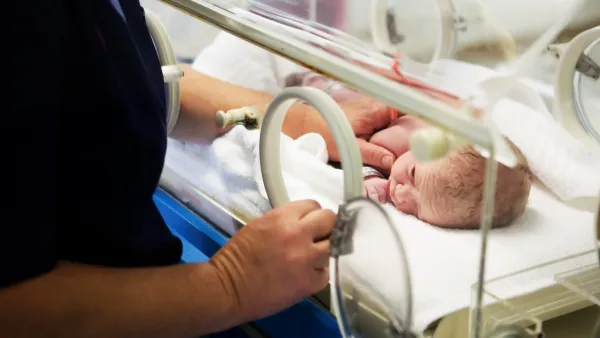Nurse and newborn in incubator