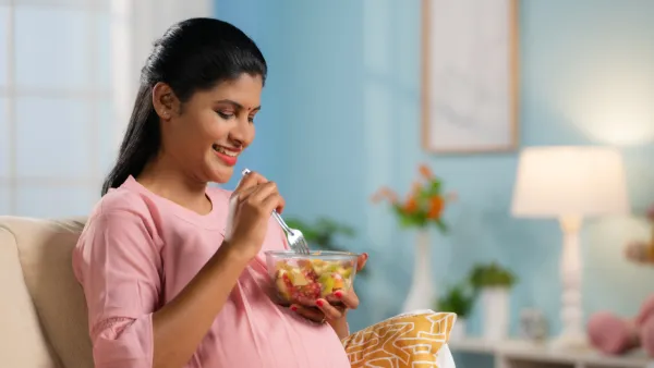 Pregnant woman eating fruit