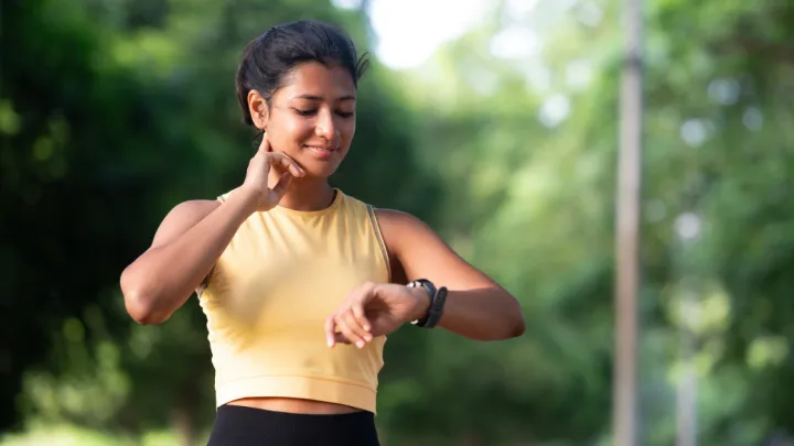 Woman exercising outside checking watch