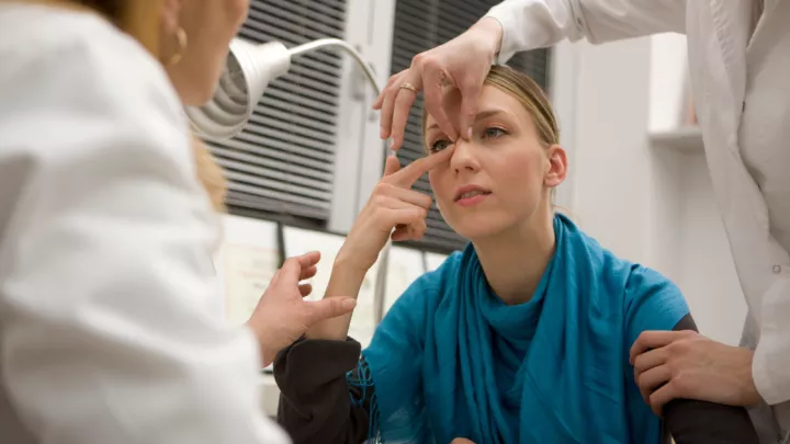 Woman in a doctor's office getting nose evaluated