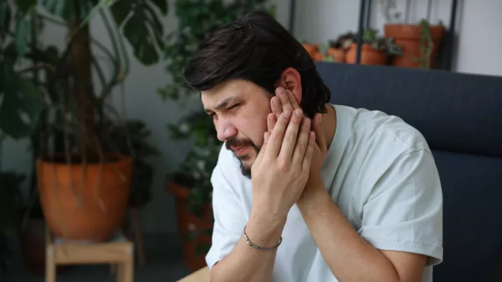 Man holding his ear