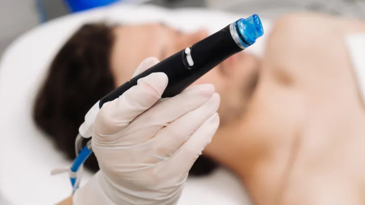 Provider holding Hydrafacial tool in front of man