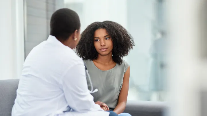 Young woman talking to doctor