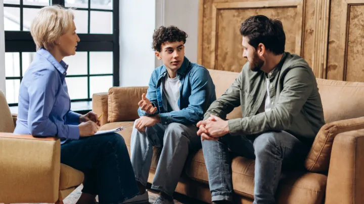 Father and son talking to therapist