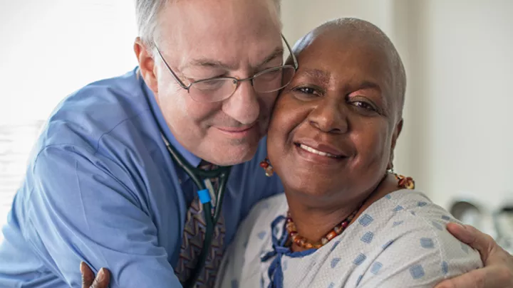 Kenneth Cowan, MD, PhD, pictured with one of his cancer patients