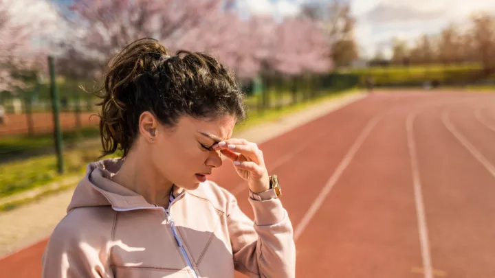 Picture of a woman on a track with a headache