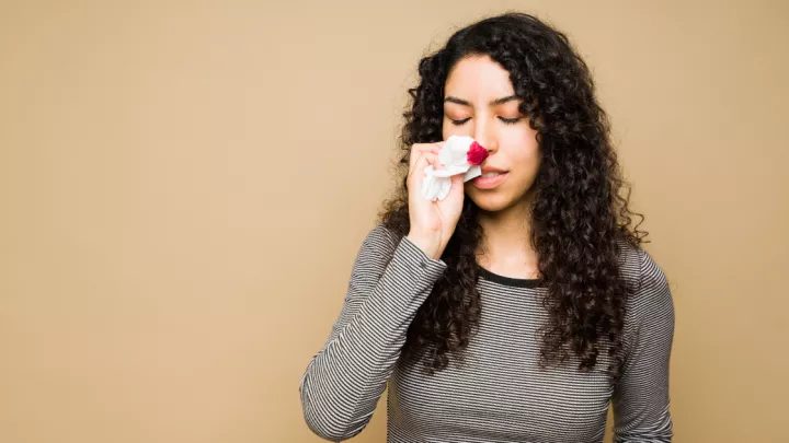 A picture of a woman with a nosebleed