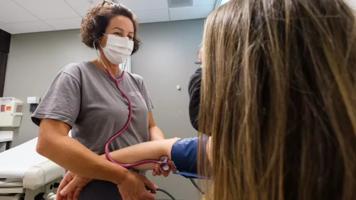 Nurse taking woman's blood pressure
