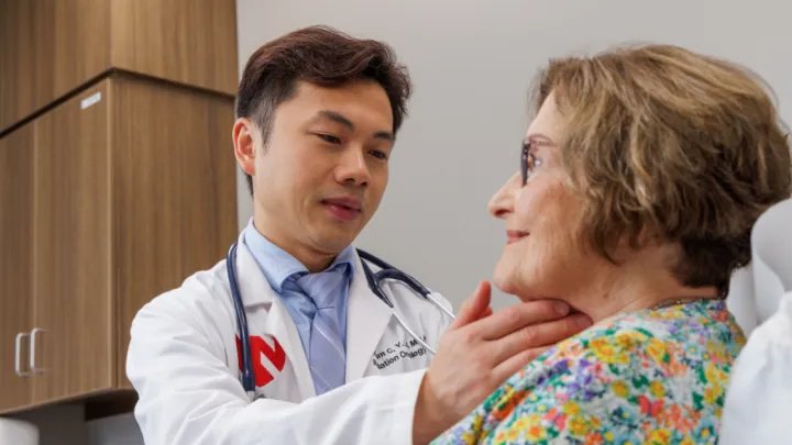 Dr. Lo feeling patient's neck