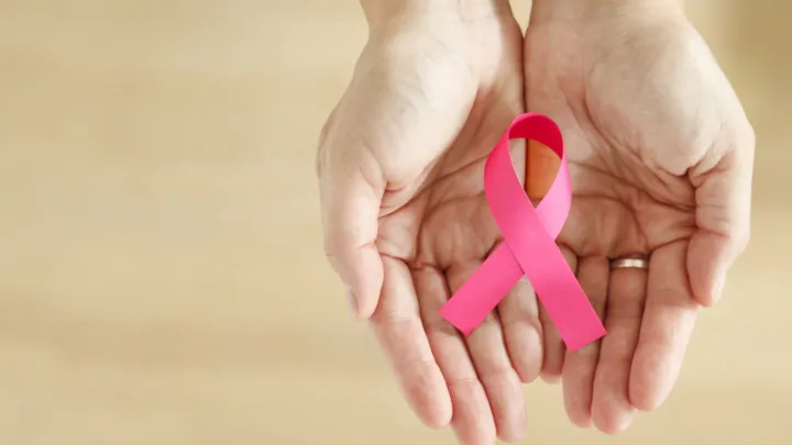 Hands holding pink breast cancer awareness ribbon