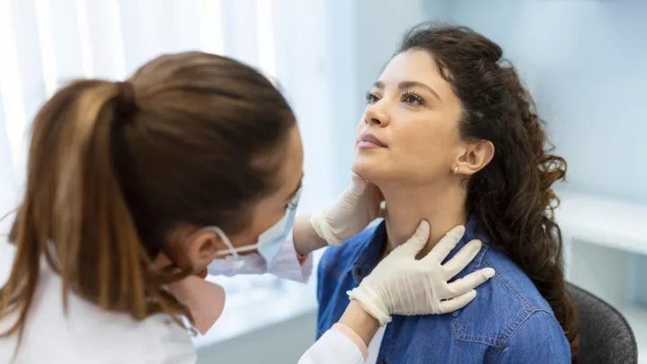 Doctor examining woman's neck