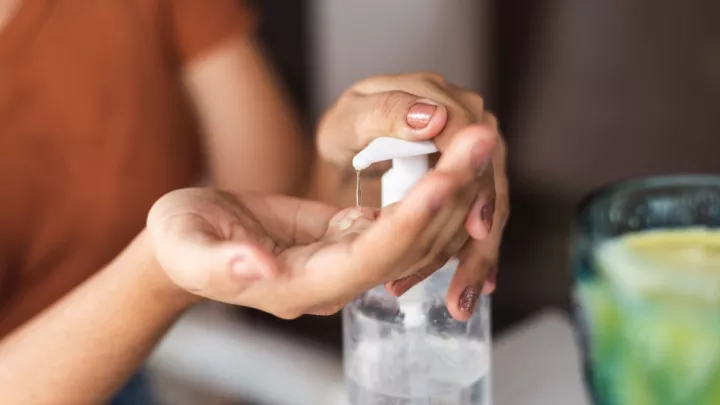 Woman putting on hand sanitizer