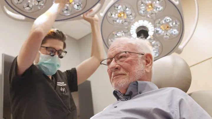 Dr. Sutton looking at Douglas Smith's scalp