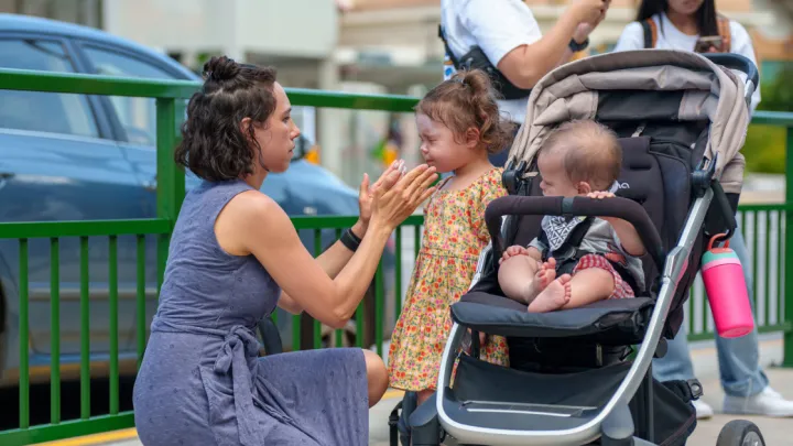 Mom putting sunscreen on her two children