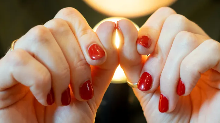 Woman holding her thumb nails together