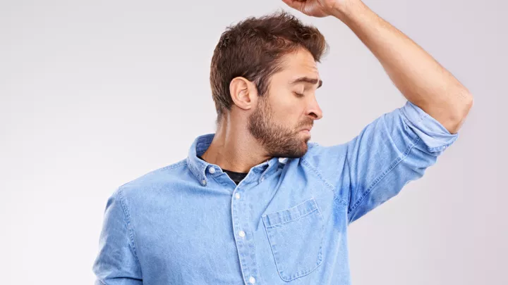 picture of a man noticing his underarm smell