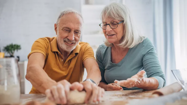 Older man and woman kneading dough