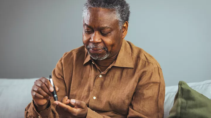 picture of a man checking his blood sugar
