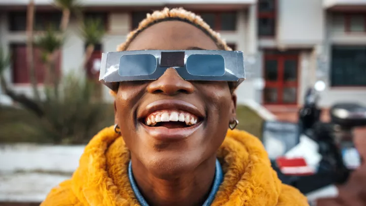 Woman wearing solar eclipse glasses