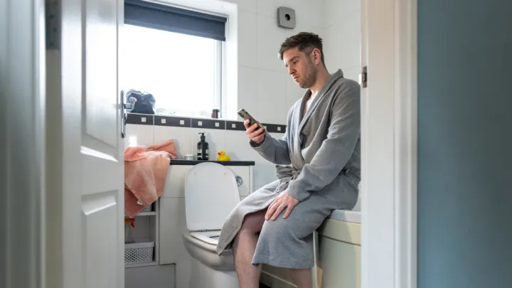 Man on phone in bathroom