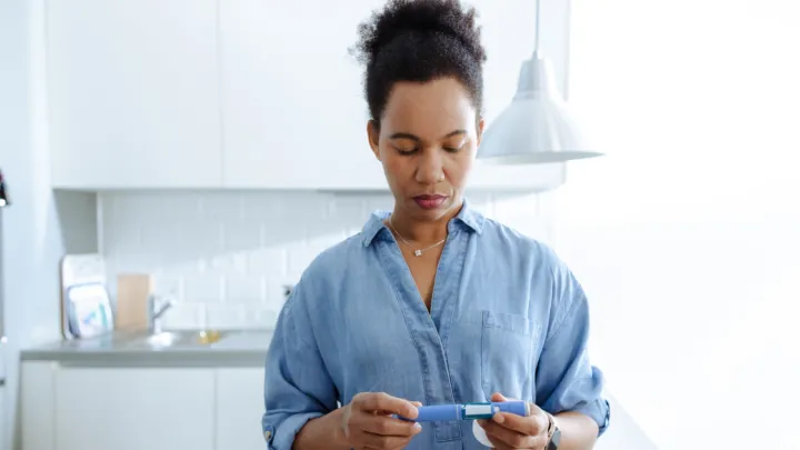 Woman holding GLP-1 injection