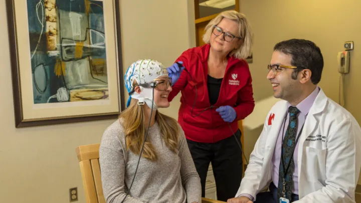 Doctor and nurse talking to patient with MEG helmet