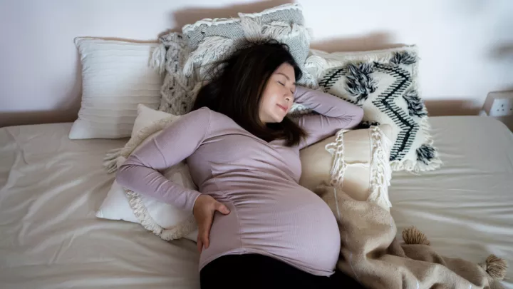Pregnant woman laying in bed