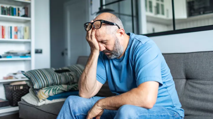 Tired man sitting on couch