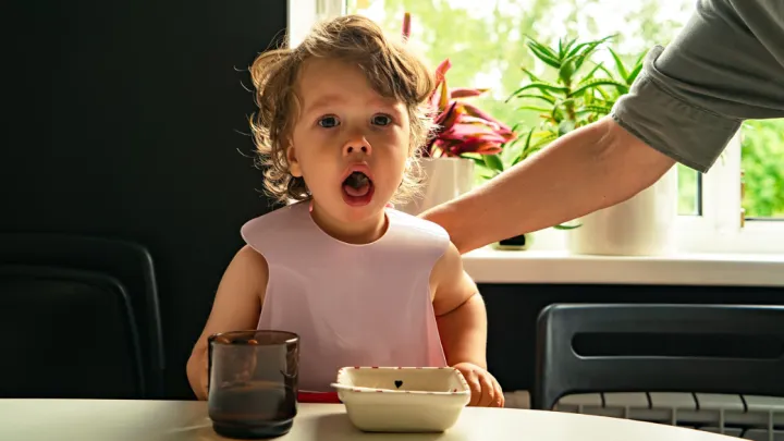 Little girl choking on food while dad pats her back
