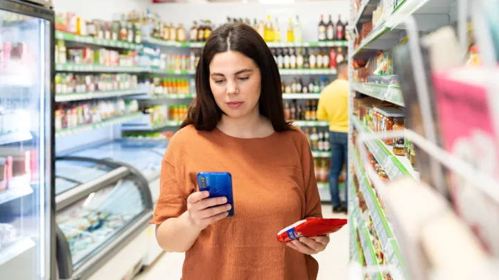 Woman in grocery store looking at her phone
