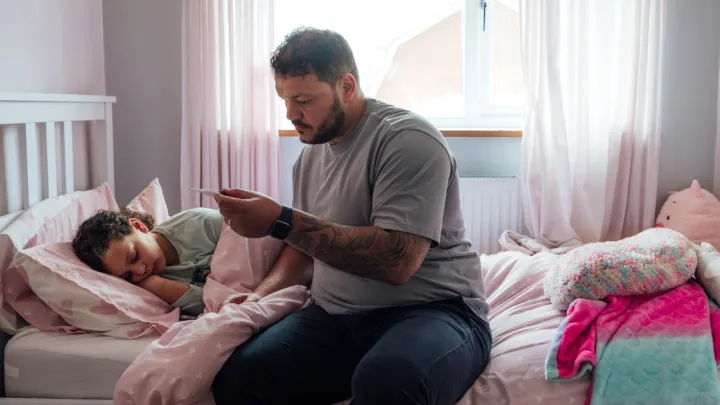 Dad taking daughter's temperature