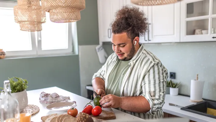 Man cutting avocado in kitchen