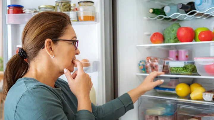 Woman looking at food in fridge