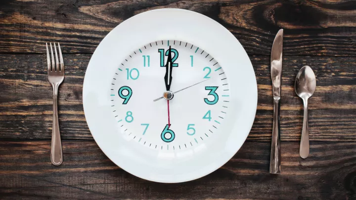Fork and knife next to a clock