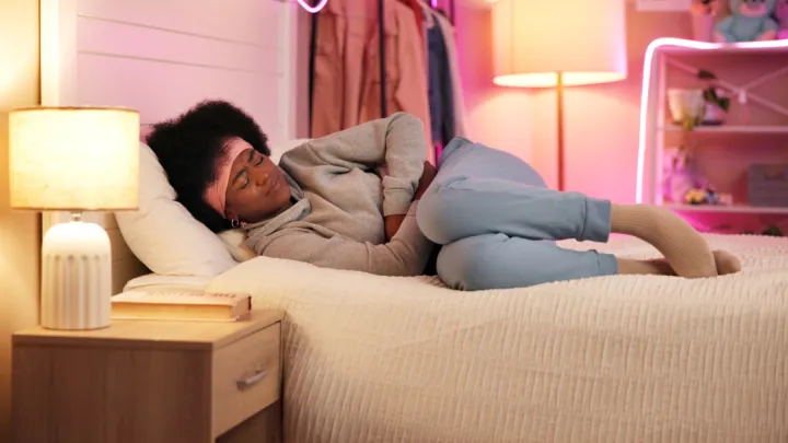 Woman with stomach pain lying in bed