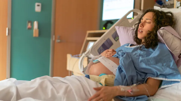 Pregnant woman in labor in hospital bed