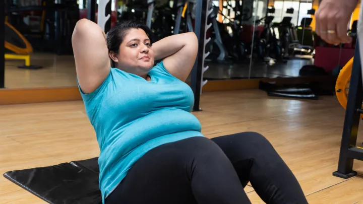 Woman doing sit-ups on gym floor