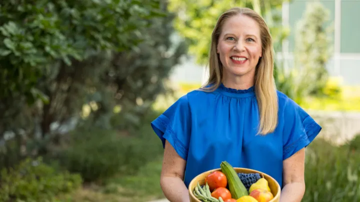 Rebecca Beaudoin, registered dietitian holding a basket of vegetables