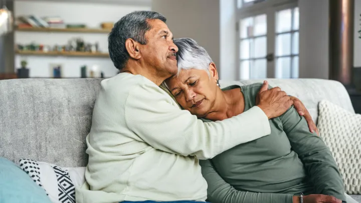 Man and woman sitting and hugging on couch